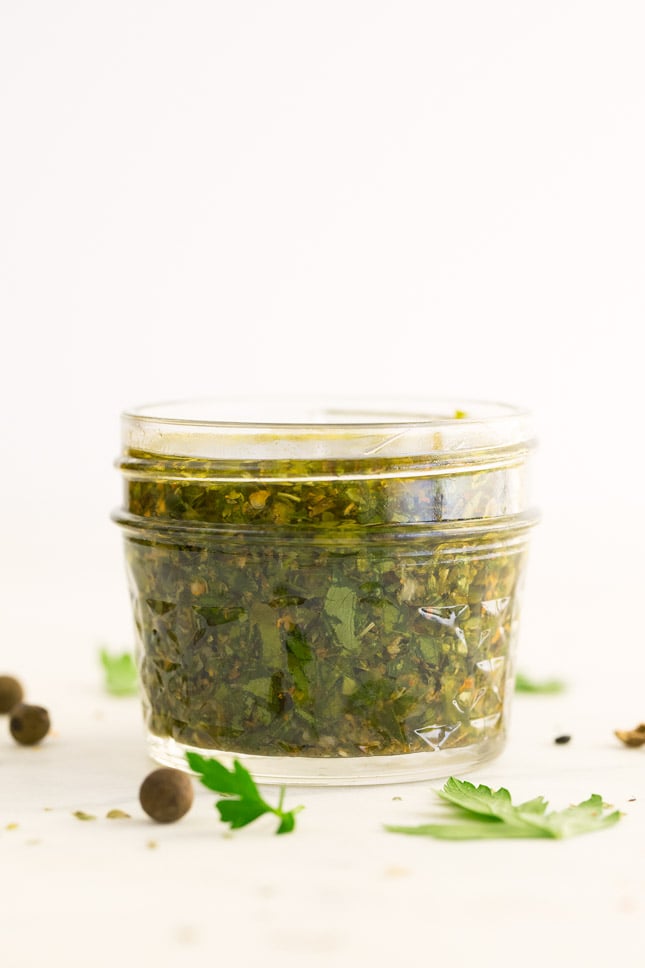 Side shot of  a little glass with chimichurri sauce in it